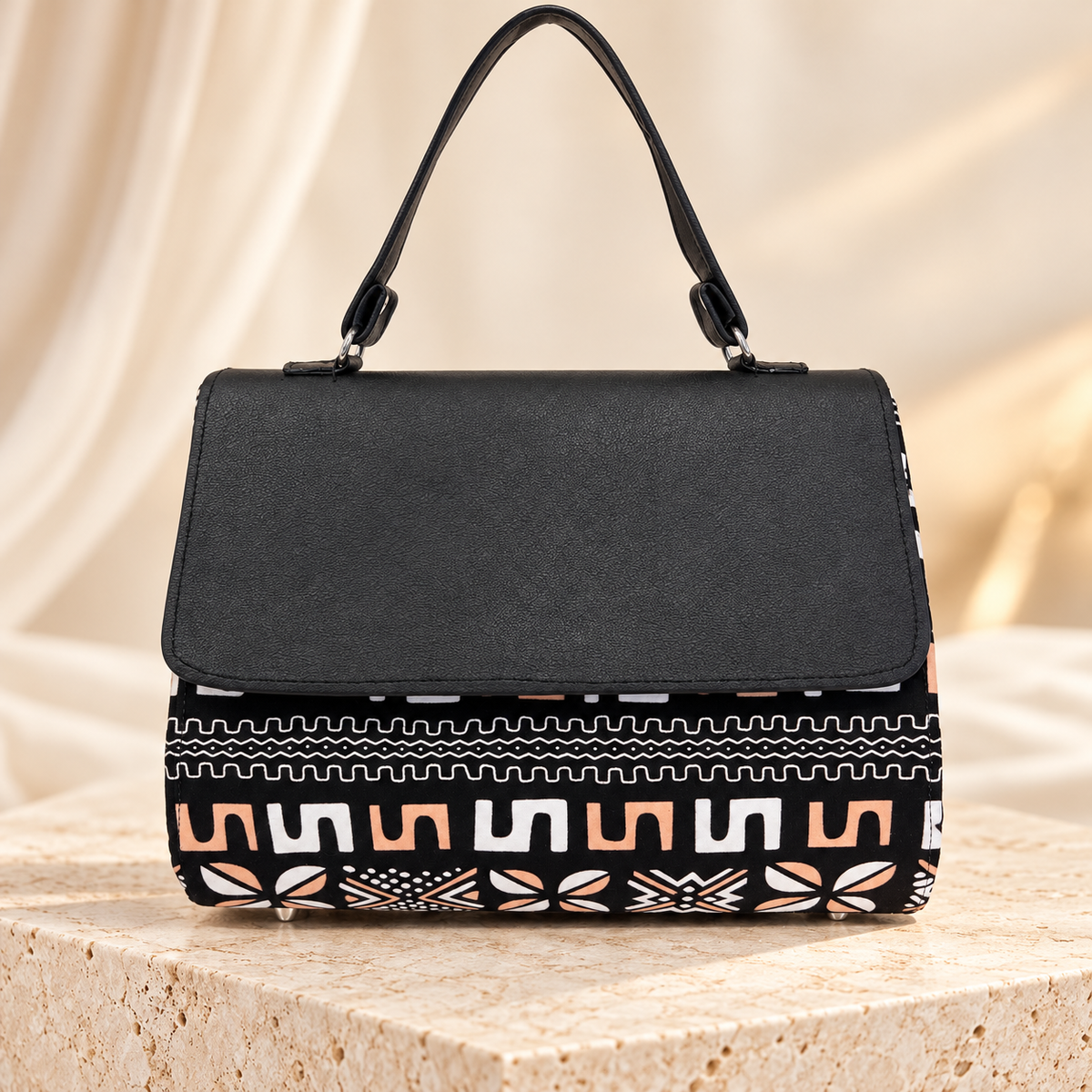 Model wearing the Hananie black mudcloth print shoulder bag with a cream blazer and elegant outfit.