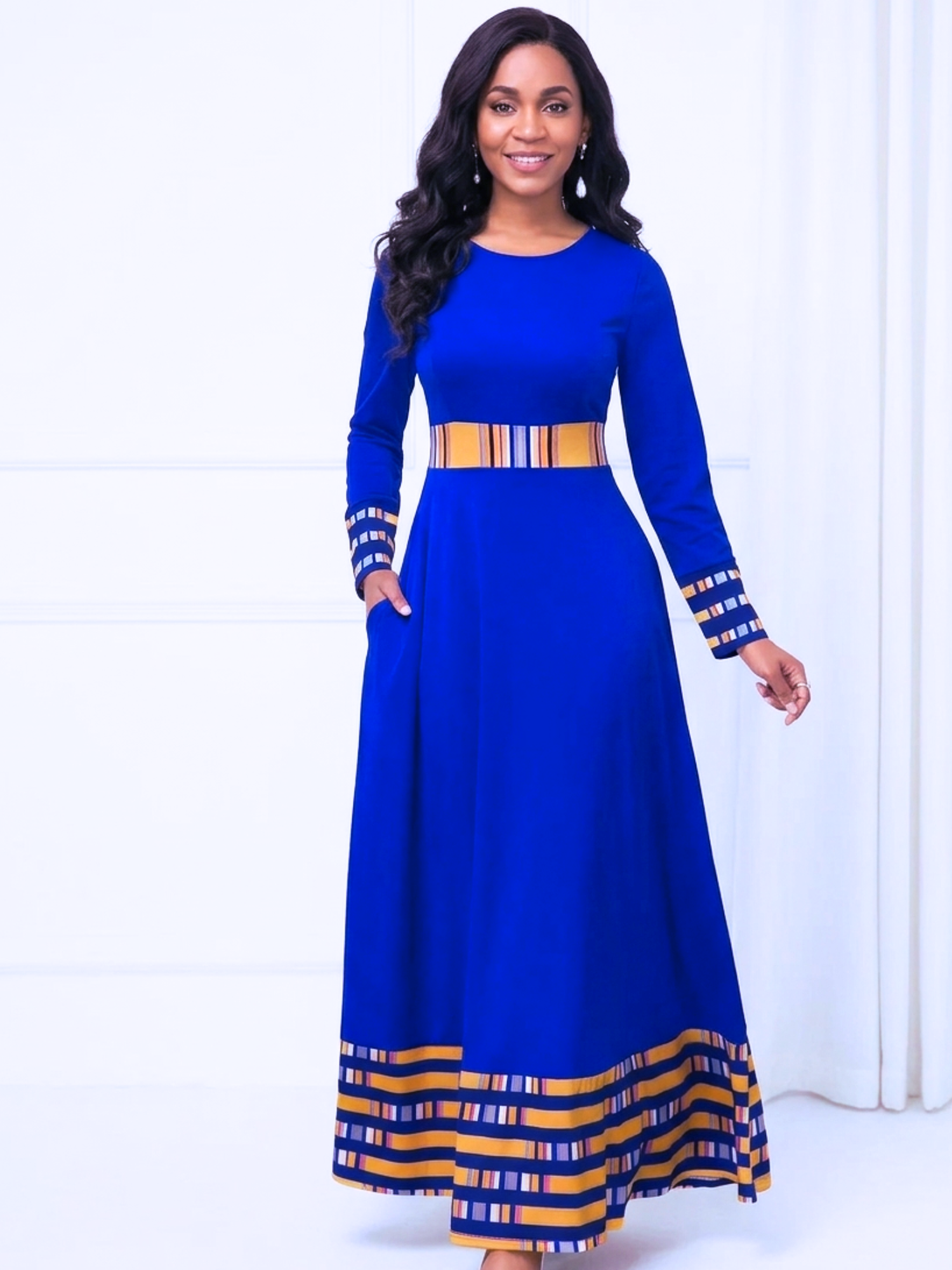 Woman wearing a blue dress with yellow accents on a white background